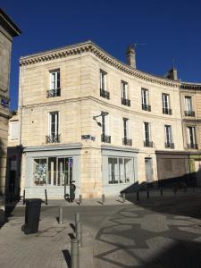 duży ceglany budynek z oknami wychodzącymi na ulicę w obiekcie Appartement De Lerme w mieście Bordeaux