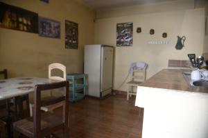 a kitchen with a refrigerator and a table and chairs at Homestay Jorge, Sucre in Sucre