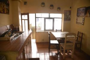 une cuisine avec une table et des chaises ainsi qu'une fenêtre dans l'établissement Homestay Jorge, Sucre, à Sucre