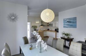 a kitchen and dining room with a table with white chairs at Villa Iva in Medulin