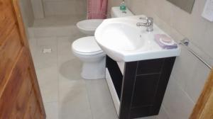 Un baño blanco con lavabo e inodoro. en Costanera, en Santa Clara del Mar 25 fotos más