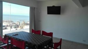 Un comedor con mesa y vista al mar. en Costanera, en Santa Clara del Mar