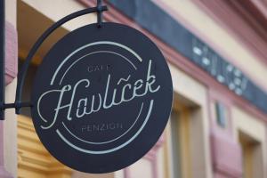 a sign for a café haulser in front of a building at Café Havlíček Penzion in Kutná Hora
