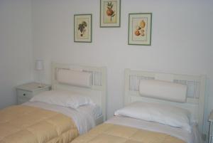 2 letti posti uno accanto all'altro in una camera da letto di Hotel Villa Verde a Ischia