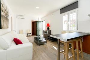 ein Wohnzimmer mit einer weißen Couch und einem Tisch in der Unterkunft Casa Macetero en Granada in Granada + 32 Fotos