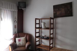 soggiorno con sedia e libreria di Suite Porto a Porto