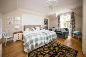 a bedroom with a bed and a couch and a chair at Invermay in Blairgowrie