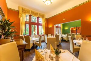 a restaurant with white tables and chairs and windows at Waldschlösschen Wangen in Wangen