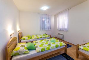 2 camas en una habitación con almohadas amarillas y verdes en Apartments Kira, en Sarajevo