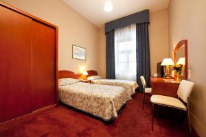 a hotel room with two beds and a window at Blue Swan in Kraków