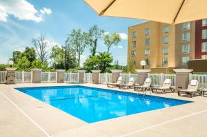 a swimming pool with chairs and a building at Country Inn & Suites by Radisson, Cookeville, TN in Cookeville