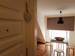 uma sala de jantar com uma mesa e cadeiras e uma porta em VDS Guesthouse Cosy Apartment in City Center em Lisboa