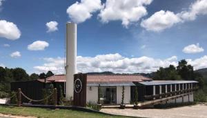 a building with a large smoke stack in a field at Pousada Cafe Poesia in Campos do Jordão