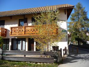 a building with a balcony and a tree in front of it at Residence Sylvana in Les Deux Alpes