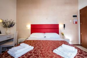 リミニにあるHotel Belmarのベッドルーム1室(赤いヘッドボード付きの大型ベッド1台付)