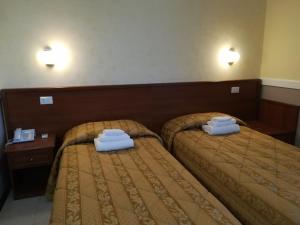 2 łóżka w pokoju hotelowym z ręcznikami w obiekcie Hotel Marco Polo SELF CHECK-IN w Bolonii