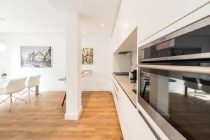 cocina y comedor con paredes blancas y suelo de madera en Atocha Boutique - Barrio de las Letras, en Madrid