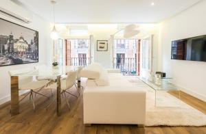 a living room with white furniture and a glass table at Atocha Museos - Barrio de las Letras in Madrid