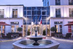 a large fountain sitting in front of a large building at Hotel Vacances Bleues Villa Modigliani in Paris