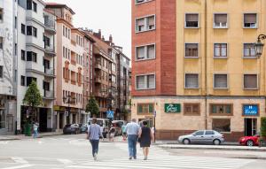 un grupo de personas cruzando una calle en una ciudad en Hostal Goias, en Oviedo
