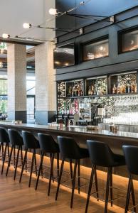 a long bar with black chairs in a restaurant at Entourage sur-le-Lac in Lac-Beauport