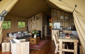 ein Wohnzimmer mit Sofa und Tisch in der Unterkunft Glamping Heidekamp in Versmold