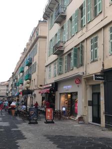 a group of buildings with tables and chairs on a street at Boutique Hôtel Neptune Nice in Nice