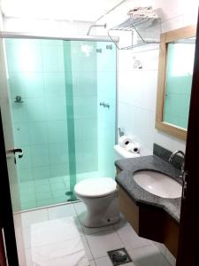a bathroom with a shower and a toilet and a sink at Águas do Paranoá in Caldas Novas