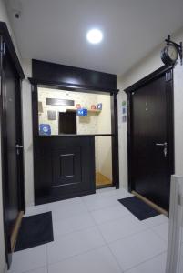 a room with a black door and a kitchen at Franstal Apartments in Belgrade