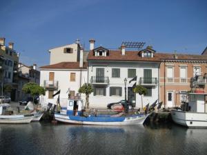 eine Gruppe von Booten, die in einem Kanal mit Gebäuden angedockt sind in der Unterkunft Villa Eleonora in Grado