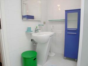 ein Badezimmer mit einem weißen Waschbecken und einer blauen Tür in der Unterkunft Villa Eleonora in Grado