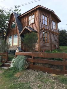 Cabaña Ahnen في أوشوايا: منزل خشبي أمامه سور