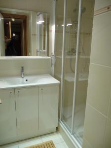 a white bathroom with a shower and a sink at Residence Sylvana in Les Deux Alpes +25 photos