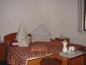 a bedroom with a bed with pillows and a table at Vila Cristina in Ceahlău