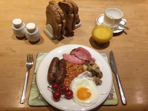 um prato de comida de pequeno-almoço com ovos, feijão de salsicha e torradas em Church Farm em Gillingham