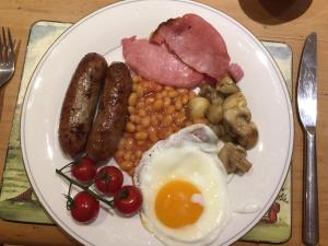 un plato de desayuno con salchichas y huevos en Church Farm en Gillingham