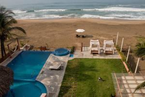 a view of a swimming pool and the beach at Hotel Villas Punta Blanca in Zihuatanejo