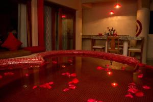 een kamer met een bad gevuld met rode kaarsen bij Hotel Villas Punta Blanca in Zihuatanejo