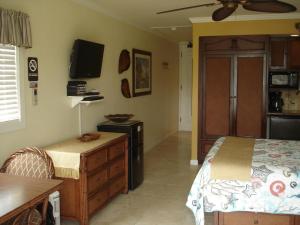 a bedroom with a bed and a dresser and a television at Islander on the Beach Unit 244 in Kapaa