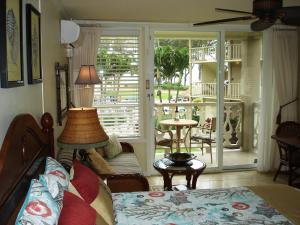 a living room with a bed and a balcony at Islander on the Beach Unit 244 in Kapaa