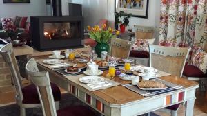 a table with food and a fireplace in a living room at Les Chambres Buissonnieres in Ladoix Serrigny