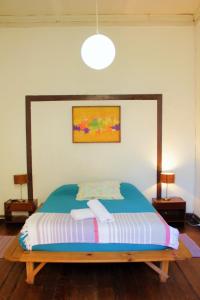 ein Schlafzimmer mit einem großen Bett mit einem Holzrahmen in der Unterkunft Casa Volante Hostal in Valparaíso