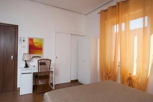a bedroom with a bed and a desk with a chair at Enjoy Vida in Casola di Napoli
