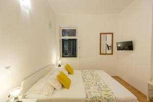 a white bedroom with a bed with yellow pillows at Villa Dubravka - heated outdoor pool and indoor jacuzzi in Zaton +33 photos