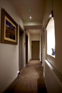 um corredor com uma pintura na parede e uma janela em The Game Cock Inn em Austwick