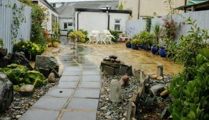 a garden with a patio with plants and rocks at Cara-Na-Mara in Killough