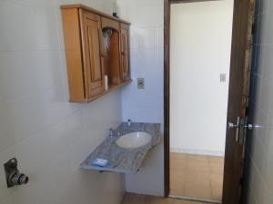 Un baño con lavabo y mueble de madera. en Cobertura próxima à praia, en Cabo Frío 26 fotos más