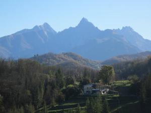 a house in a valley with mountains in the background at Vista Alpi Apuane in Rometta