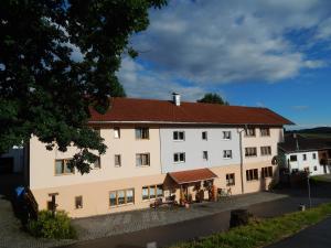 un gran edificio blanco con techo rojo en Ferienwohnung Vogl, en Drachselsried