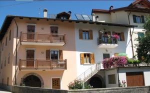 un gran edificio blanco con balcones y flores. en Agritur Odorizzi, en Tassullo